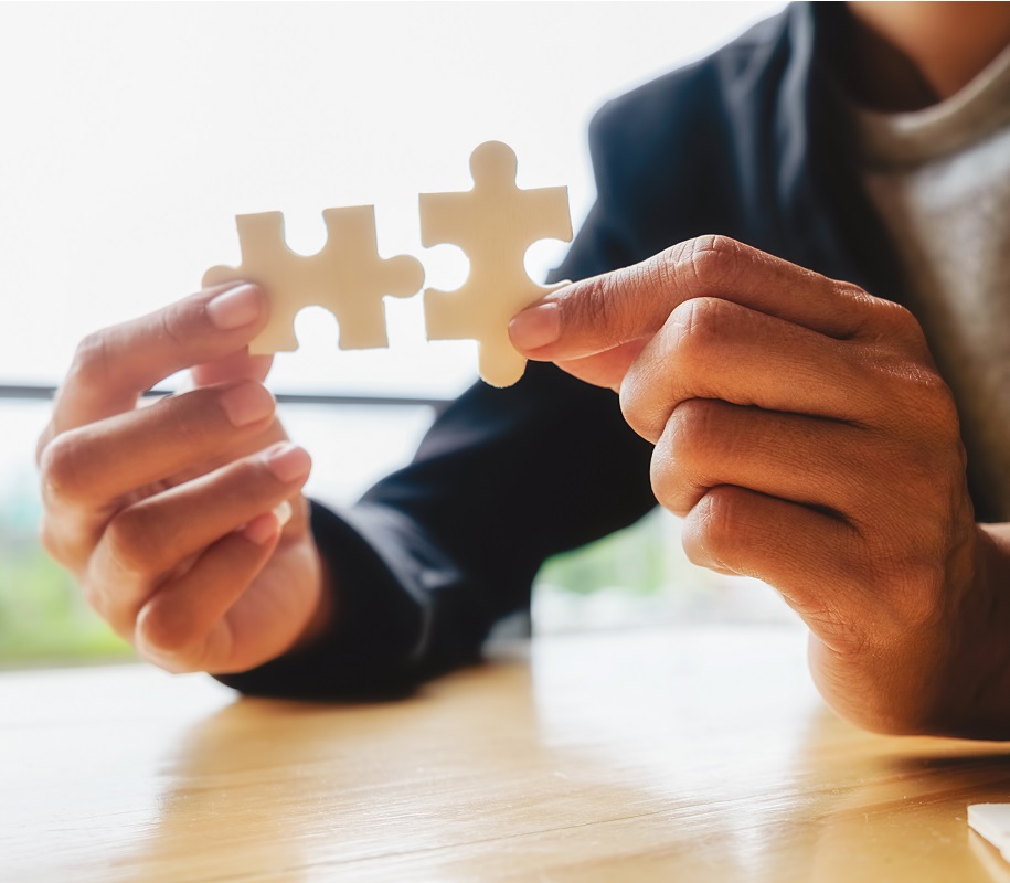 Business woman hands connecting jigsaw puzzle. Business solutions, success and strategy concept. Businessman hand connecting jigsaw puzzle.Close up photo with selective focus.